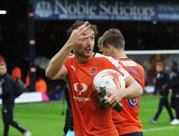 Danny Hylton with the match ball at the end of the game. He lets people know he did score three