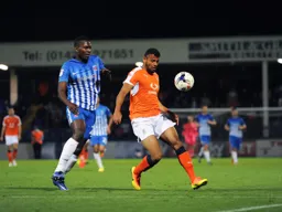 Isaac Vassell is the first to the ball