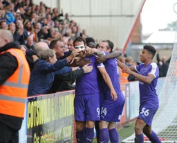 Danny Hylton celebrates his goal with some of the Hatters travelling fans