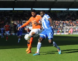 Isaac Vassell forces his way past George Elokobi