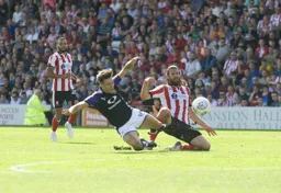 Harry Cornick and Michael Bostwick slide in for the ball
