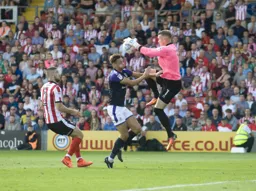 Paul Farman catches the ball under pressure from Harry Cornick