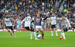 Andrew Shinnie trying to progress the ball through midfield, but can't get past Jayden Bogle, his brother Graeme watches on.