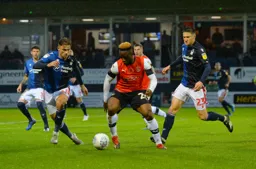 Kazenga LuaLua is trying to progress the ball under the watchful eyes of Matty Cash and Joe Lolley