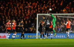 James Shea rises highest to clear the danger from a set piece with Tom Lockyer challenging for the ball