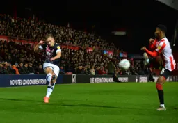 Luke Bolton sends in a cross, it's blocked by Rico Henry