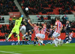 Matty Pearson challenging Jack Butland for the ball, but the goalkeeper punches clear