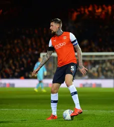 Sonny Bradley with his foot on the ball in the opposition half looking for who's open