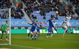 Glen Rea sends in a header towards goal, Kal Naismith trying to block it