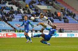 Harry Cornick hurdles Cedric Kipre, as future hatter Kal Naismith looks on