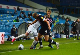 Danny Hylton battles with Jack Harrison for the ball