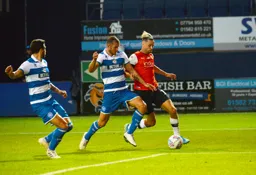 Harry Cornick bursting into the box under the challenge of Yoann Barbet