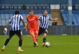 Tom Lockyer passes the ball before former Hatter Jack Marriott can make a tackle