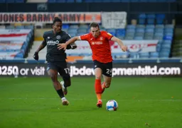 Rhys Norrington-Davies goes on a run chased by Ivan Toney