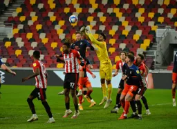 David Raya punches the ball away from Jordan Clark