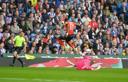 Elijah Adebayo tries to hurdle Sam Johnstone