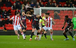 Danny Hylton getting the ball past Ashley Williams