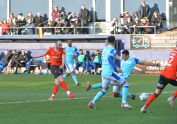 Danny Hylton slides in a vital winner from the edge of the box through former Hatter Curtis Davies' legs