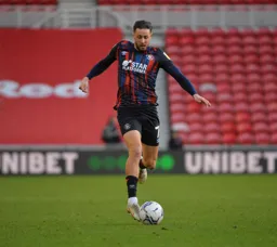Harry Cornick striding forward with the ball