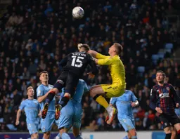 Tom Lockyer challeges for the ball