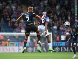 James Bree heads the ball down under pressure from Ian Maatsen