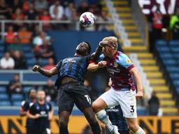 Elijah Adebayo bends his back to reach the ball