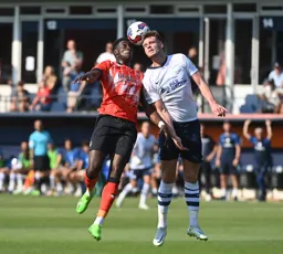 Elijah Adebayo and Liam Lindsay head the ball against each other