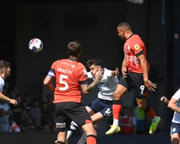 Carlton Morris heads the ball towards goal