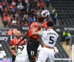 Elijah Adebayo goes for header as his shirt is held by Ben Cabango