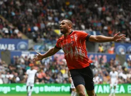 Carlton Morris celebrates his goal in front of the travelling Hatters fans