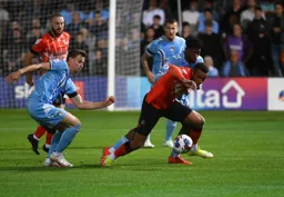 Carlton Morris gets down low as he comes away with the ball