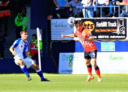 Tom Lockyer heads the ball on