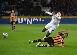 Alfie Jones puts in a sliding tackle on Elijah Adebayo