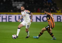Henri Lansbury plays a pass as Ozan Tufan closes in