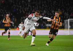 Carlton Morris bursts forward with the ball as he holds off Regan Slater