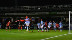 Elijah Adebayo sends in a towering header but it drifts wide of the goal