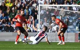 Jed Wallace pushes the ball through Henri Lansbury`s legs