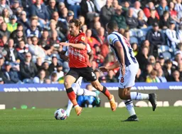 Tom Lockyer drives forward with the ball