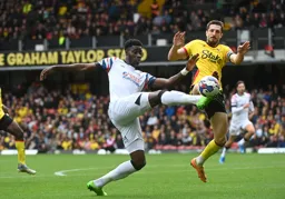 Elijah Adebayo goes for the ball under pressure from Craig Cathcart