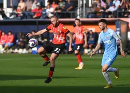 Allan Campbell controls the ball as Leon Dajaku closes in