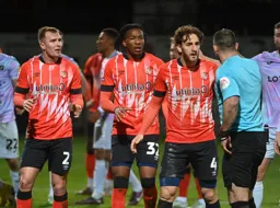 The referee has just shown Gabriel Osho the red card. Tom Lockyer leads the protests