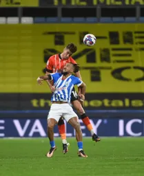 A shirt grabbing Reece Burke gets his head to the ball