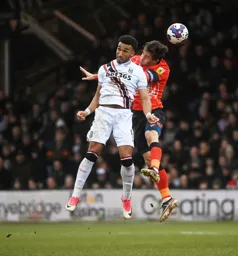 Tom Lockyer goes for a header against future Hatter Jacob Brown
