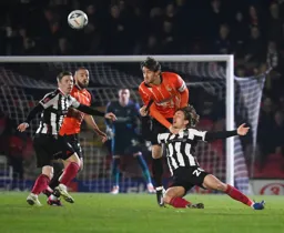 Tom Lockyer climbs all over Dani Orsi-Dadomo to head the ball clear