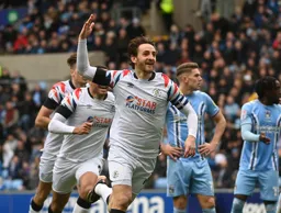 Tom Lockyer raises his arm in triumph