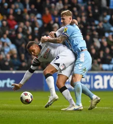 Carlton Morris is held back by Kyle McFadzean