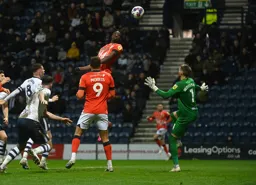 Elijah Adebayo trys to head the ball over Freddie Woodman