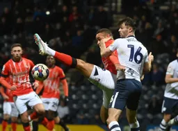 Carlton Morris goes for the ball with a straight leg