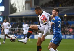 Carlton Morris controls the ball under pressure from Gary Gardner