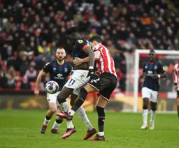 Eiljah Adebayo shields the ball from John Egan